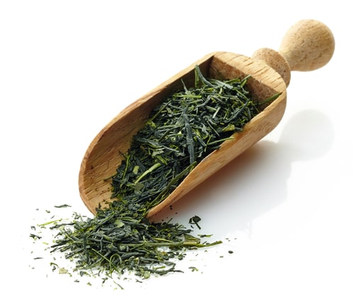 Gyokuro tea leaves displayed on a wooden scoop 